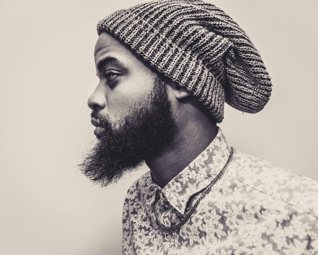 pexels photo 1205405 1205405 Profile photo of a bearded man in a knit hat and floral shirt, exuding modern style.